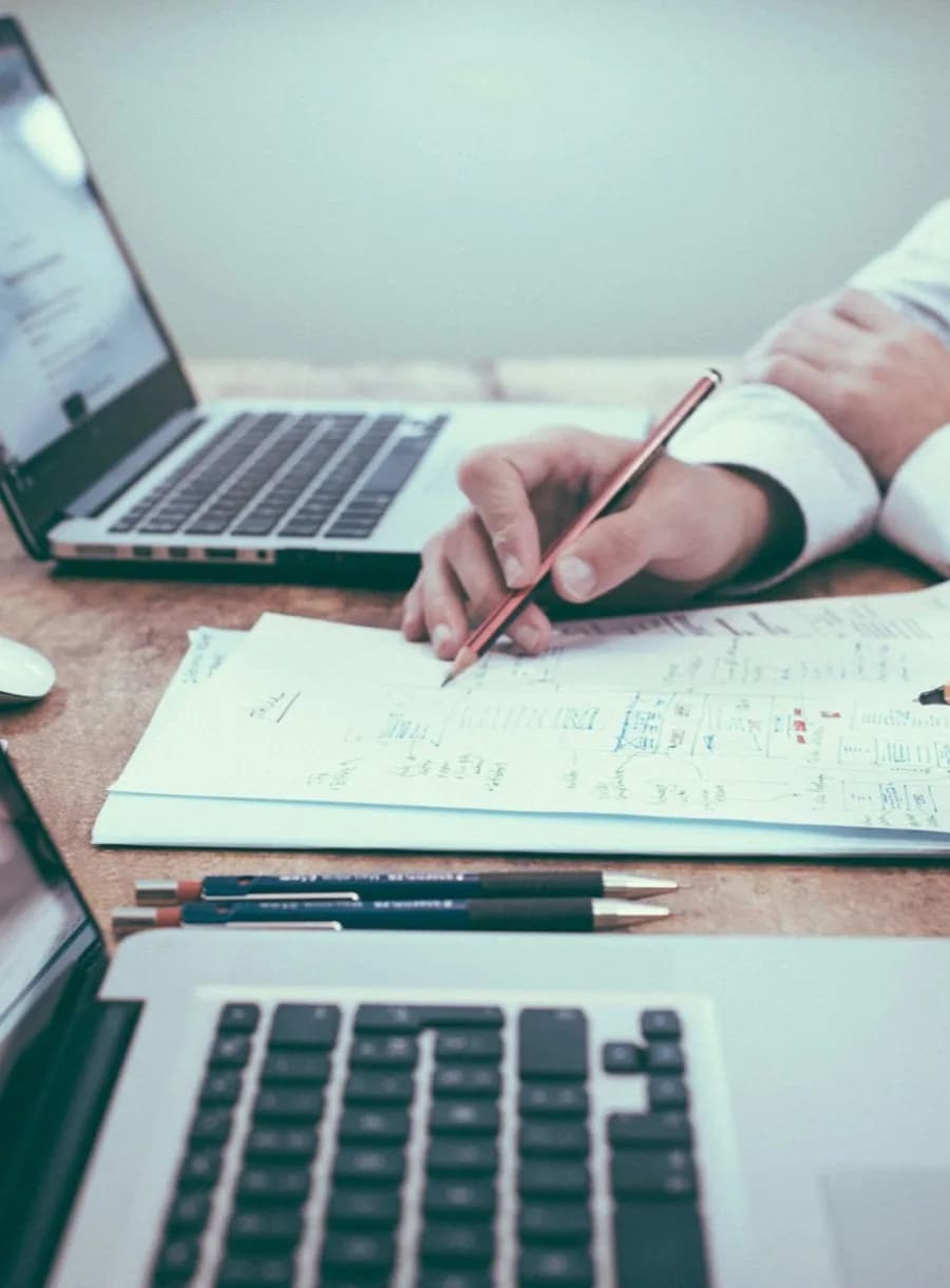 Profissionais analisando relatórios e planilhas sobre a mesa